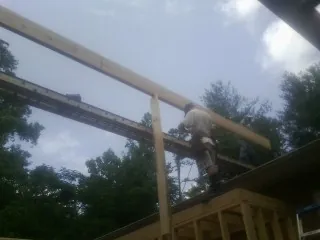 Carpenter setting a ridge beam over a new addition frame — Ice Dam Removal by Roofing Brothers in Pottersville