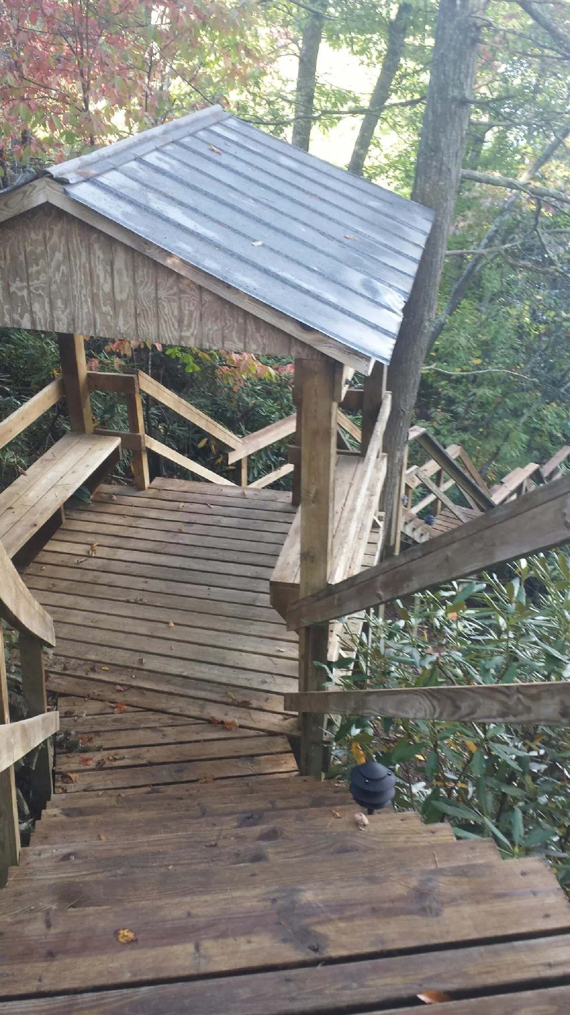 Metal roofed shelter over wooden steps on a wooded walkway — Skylight Repair & Installation work by our crew in Pottersville