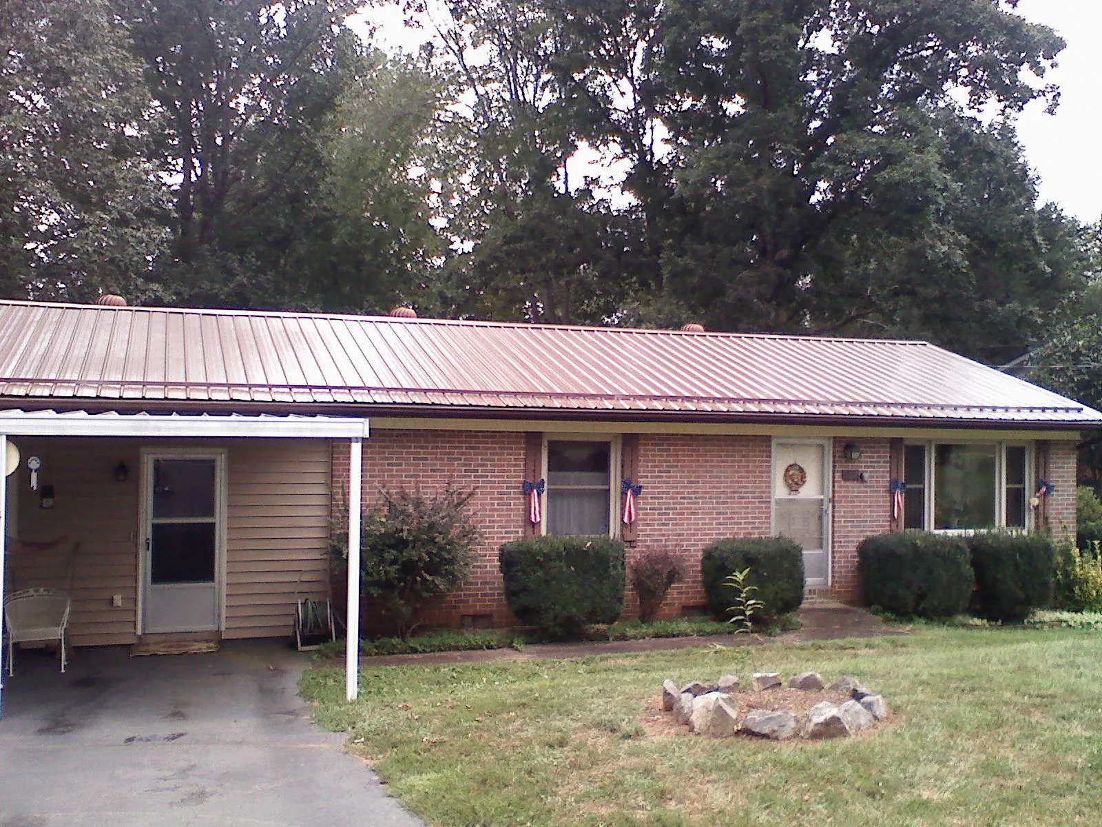 Bronze metal roof and carport on a brick ranch home — Roof Repair work by our crew in Pottersville